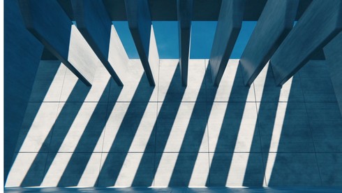 Modern architecture with blue geometric patterns and sunlight